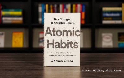 Hardcover copy of Atomic Habits by James Clear displayed on a bookshelf.