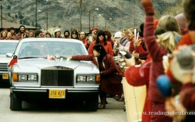 Followers of Osho greeting a silver Rolls Royce on a road in Oregon, with the "Reading to Heal" watermark.