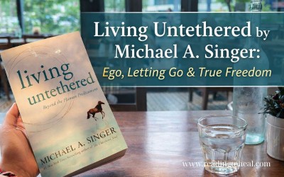Living Untethered book by Michael A. Singer on a wooden table in a calm cafe setting, symbolizing inner freedom and spiritual awakening