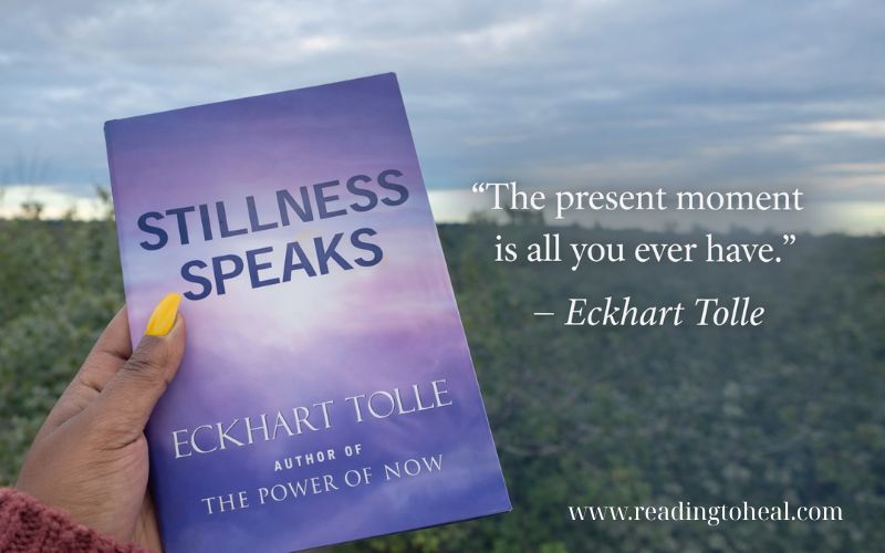 Stillness Speaks book against cloudy sky with Eckhart Tolle quote about the present moment and mindful awareness