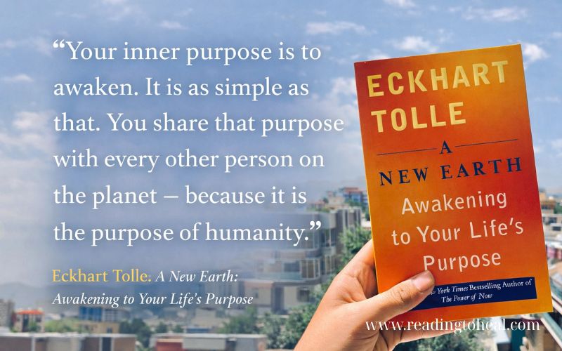 A New Earth by Eckhart Tolle quote about awakening and inner purpose, book cover held in hand with city background, mindfulness and spiritual awakening theme